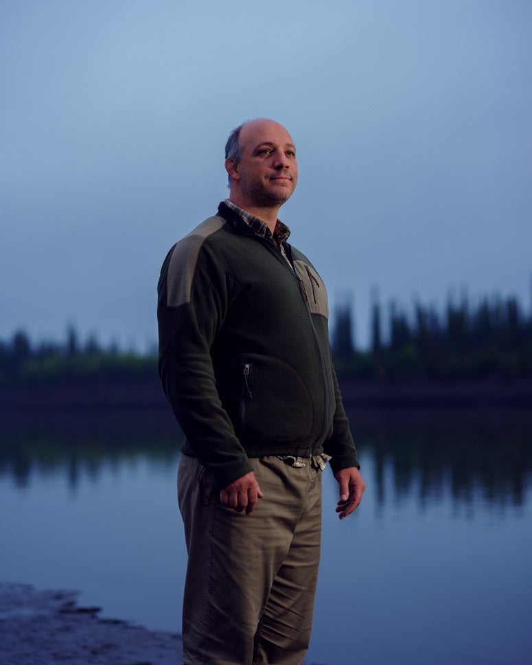 'Alone' Season 11 cast member Peter Albano standing in front of a lake