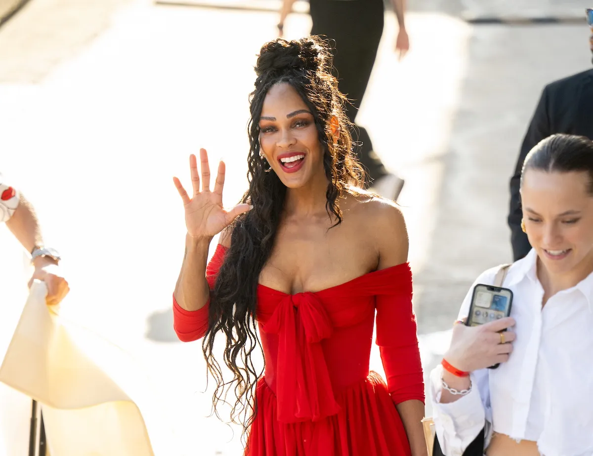 Meagan Good waves while wearing an off-the-shoulder red minidress